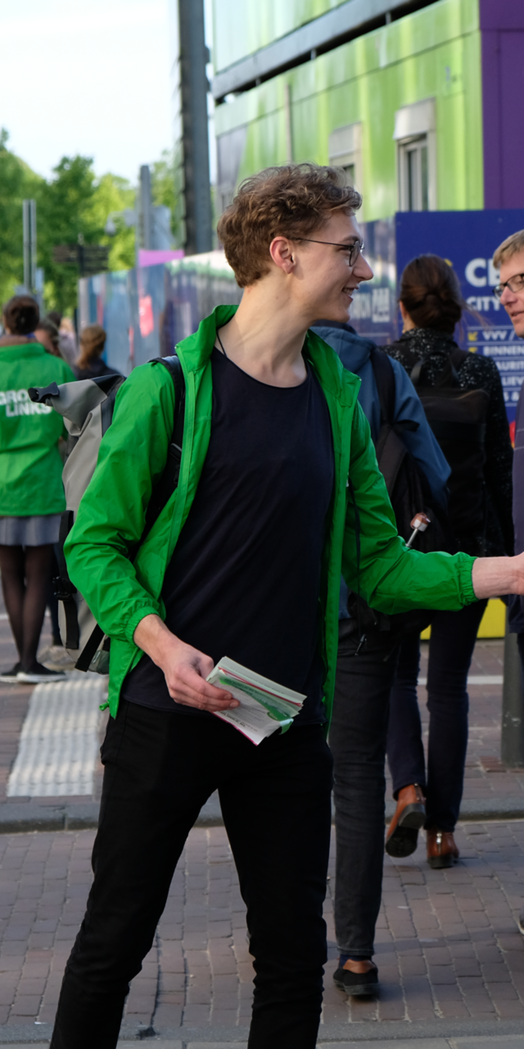 Een GroenLinks-vrijwilliger deelt flyers uit