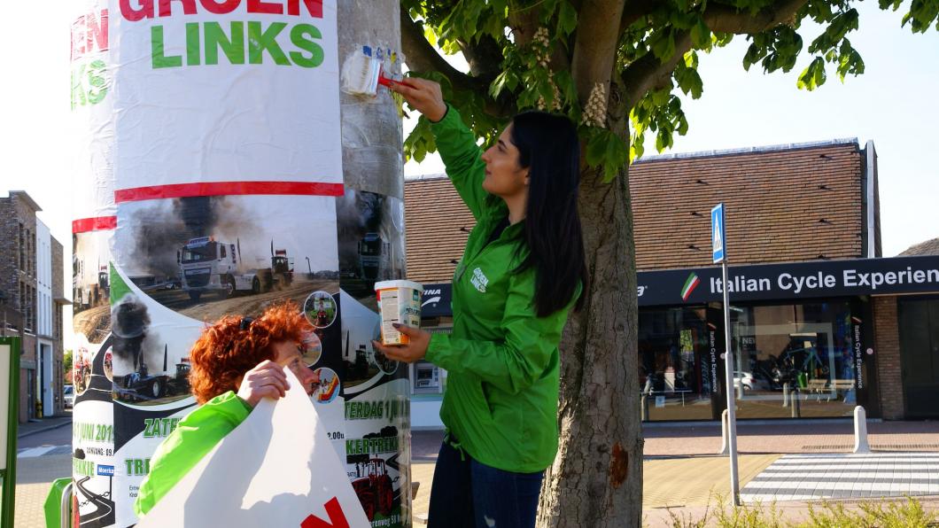 Posters plakken in het centrum van Bergschenhoek